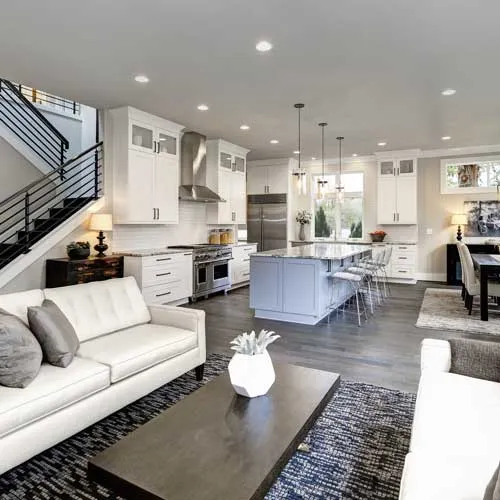 Remodeled living area with wood flooring and layered lighting